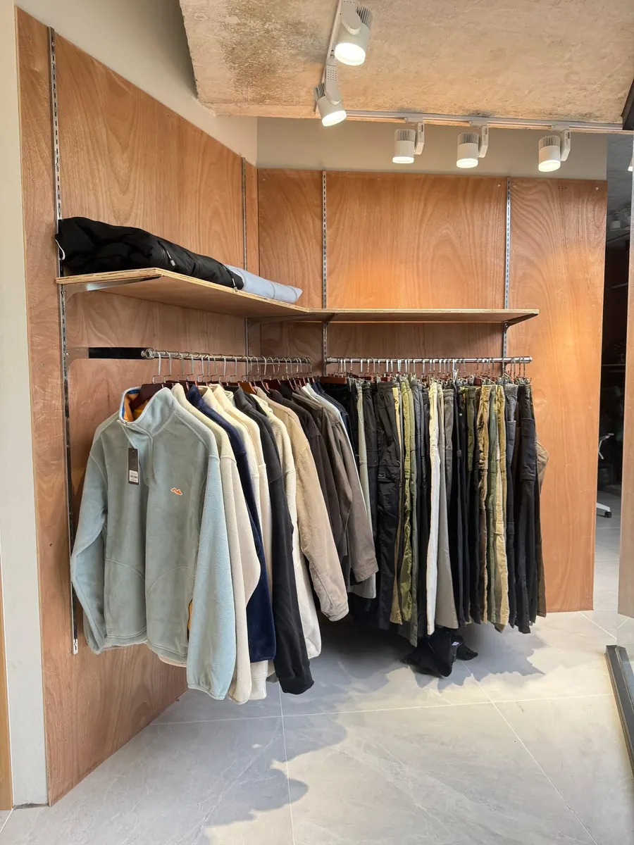Fleece tops and trekking trousers on the plywood wall display